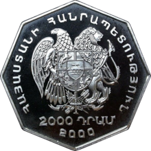 Eine achteckige silberne Münze, die einen großen doppelköpfigen Adler mit einem Wappenschild zeigt. Unten steht 2000, rundherum steht ein Text in armenischer Schrift