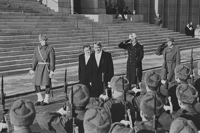 Newly sworn President Martti Ahtisaari (2nd left) inspects the company of honor with outgoing President Koivisto (c.), followed by others, c. 1994