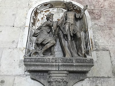 Groupe sculpté en pierre représentant deux hommes barbus, l'un est debout et l'autre a un genou à terre. En dessous de la scène, écritures en français.
