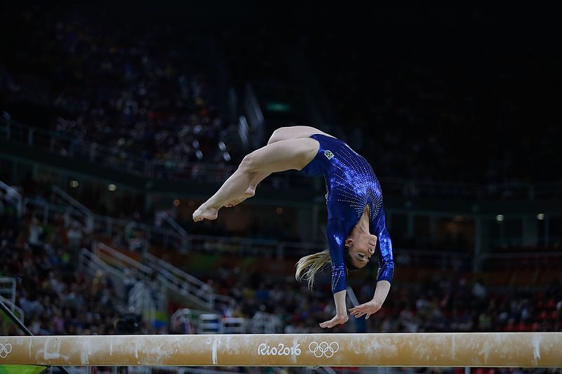 Exercising woman holding gymnast rings. Female taking rest after