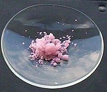 Erbium(III) chloride in sunlight, showing some pink fluorescence of Er from natural ultraviolet. Erbium(III)chloride sunlight.jpg