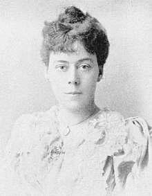 B&W portrait photo of a middle aged woman with brown hair in an up-do.