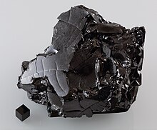 A large sample of glassy carbon Glassy carbon and a 1cm3 graphite cube HP68-79.jpg