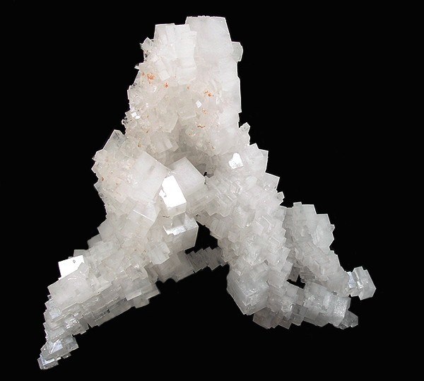 Halite, the mineral form of sodium chloride, forms when salty water evaporates leaving the ions behind.