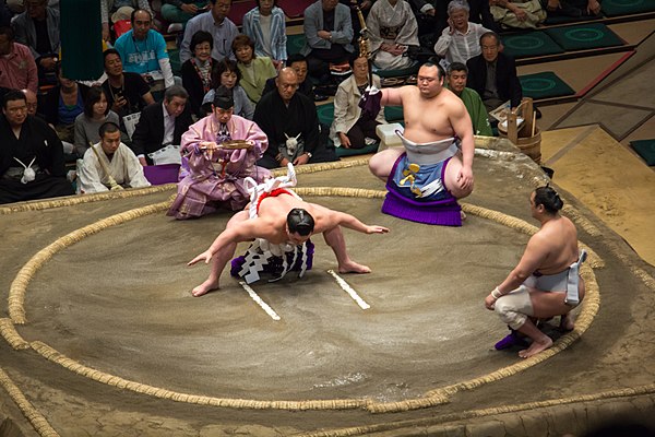 Harumafuji (center) performing his yokozuna ring-entering ceremony in May 2014