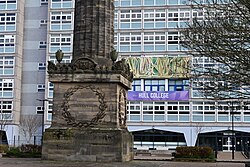 Detail of signage on the main tower block of Hull College, as well as the base of the Wilberforce Monument.