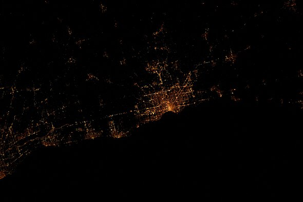 The city at the center is Milwaukee. The photo was taken at 11:23:40 PM CDT in 2012 during Expedition 30 at the International Space Station. Due to the angle of the photo, north points rightwards, and west upwards.