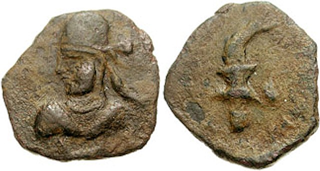 Coinage of Pahares I, Indo-Parthian king of Turan (Circa 160-230 CE). Bearded bust left, wearing Parthian-style tiara. Crude figure of Nike walking ri