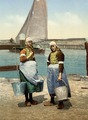 Two girls on the isle of Marken, the Netherlands, carrying water buckets on a yoke (circa 1900)