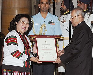 Woman on left receiving award from man on right