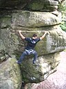 ☎∈ A rock climber scaling a sandstone crag at High Rocks outside Tunbridge Wells, UK.