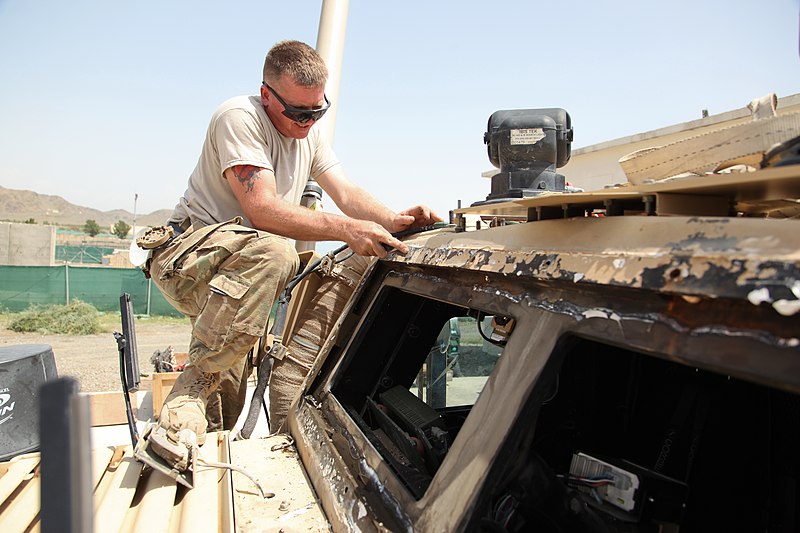 File:U.S. Navy Construction Mechanic 1st Class William Cook, assigned to Construction Battalion Maintenance Unit 202, attached to the Khost Provincial Reconstruction Team, scrapes off excess sealant after removing 120811-A-PO167-085.jpg