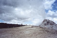 Thin geyser shooting out of a cratered dome.