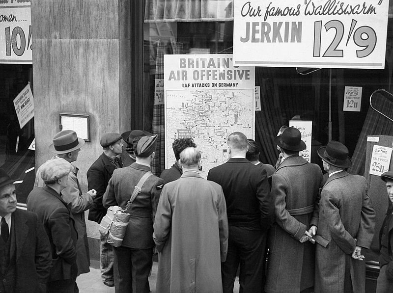 File:A British airman is amongst a group of civilians crowded around the window of a shop in Holborn, London, to look at a map illustrating how the RAF is striking back at Germany during 1940. D1254.jpg