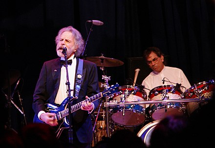 Mickey Hart (in background, playing drums) and Bob Weir (playing guitar) performing at the Mid-Atlantic Inaugural Ball during the presidential inauguration of Barack Obama, January 20, 2009
