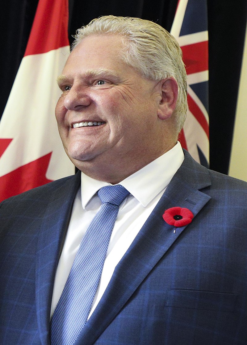 Ford in 2018 wearing a navy blue suit and a poppy.