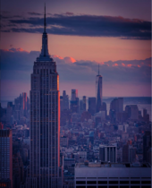 The Empire State Building in the foreground looking southward from the top of Rockefeller Center, with One World Trade Center in the background, at sunset. The Midtown South Community Council acts as a civic caretaker for much of the neighborhood between the skyscrapers of Midtown and Lower Manhattan. Past Vs. Present.png