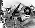 Grumman F6F-3 "Hellcat" fighters landing on USS Enterprise (CV-6) after strikes on the Japanese base at Truk, 17-18 February 1944. Flight deck crewmen are folding planes' wings and guiding them forward to the parking area