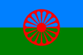 Flag of the Romani People. It contains blue and red colour to represent the heaven and earth respectively, and uses a 16 spoke Dharmachakra to symbolise their tradition and to pay homage to their Indian origin.