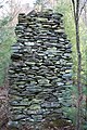 Old river rock chimney in the forest is all that is left from old settlment in Floyd County, USA. back