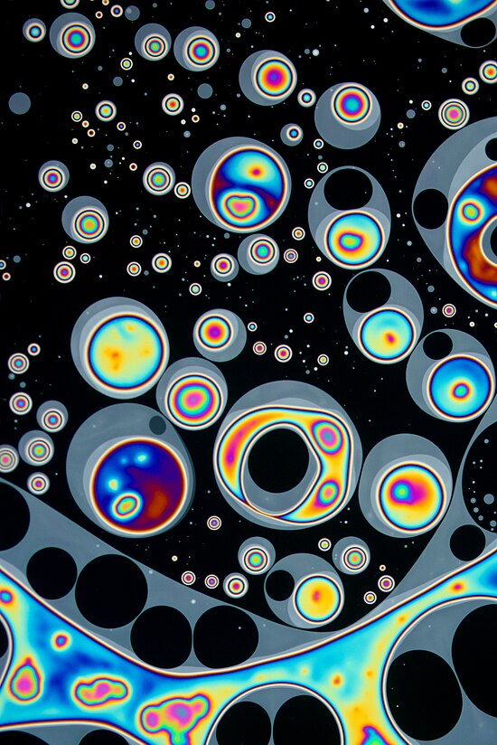 A close-up image of the surface of a soap bubble. Show another
