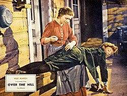 Mae Marsh as a young mother in the film Lobby card of Mae Marsh and Tommy Conlon in Over the Hill (1931) (cropped).jpg