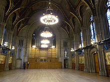 The twelve murals are located on opposite walls in the Great Hall. Manchester Town Hall, Great Hall.jpg