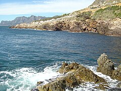 A view towards the north east shoreline. The cave is just below water level in the second inlet from the right.