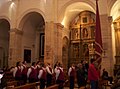 Alcuni gremianti portatori dei fabbri, durante la festa di Sant'Eligio nella cattedrale di Sassari. Davanti a loro in giubba rossa dei componenti del gremio gemellato di Alghero con la loro bandiera.