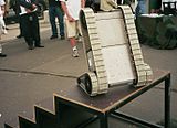 A grey military robot on a staircase.