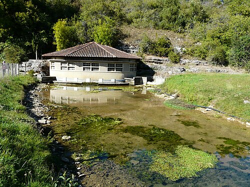 Karstquelle der Glane mit Pumpenhaus, dahinter flach nach Nordost einfallendes Unter/Mittelbathonium