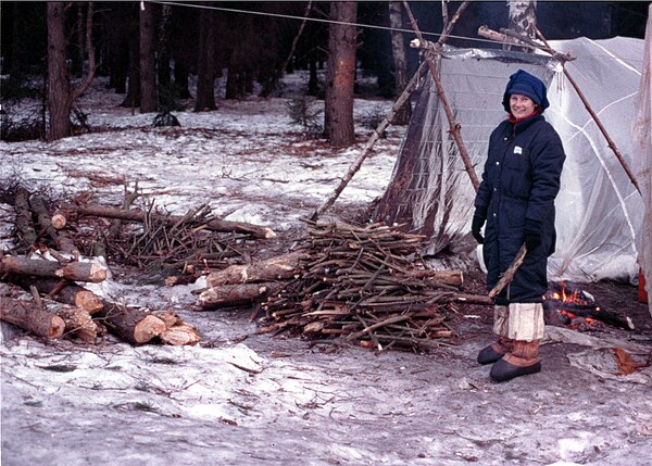 Astronaut Susan Helms gathers firewood during winter survival training.