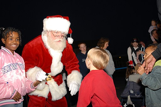 US Navy 061127-N-7987M-039 Santa greets his guest during Operation Christmas at the Army National Guard Armory