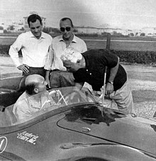 Founder "Mimmo" Dei (center, with sunglasses) surrounded by Guerino Bertocchi (mechanic, seated in Maserati A6GCS/53) and team drivers Giorgio Scarlatti (left) and Piero Taruffi (right). 1956 Maserati A6GCS-53 Bertocchi Scarlatti Dei Taruffi.jpg