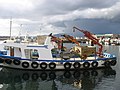 Barco mexilloeiro no porto de Vilanova de Arousa. Véxase o guindastre, o cesto, a moega e a grella para clasifica-lo mexillón