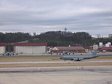 KC-135R Stratotanker berangkat dengan Alabama Air National Guard hanggar dan bangunan di belakang.