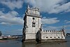 Torre de Belém (Belém Tower), one of Lisbon's most famous landmarks, with Ponte 25 de Abril in the background.