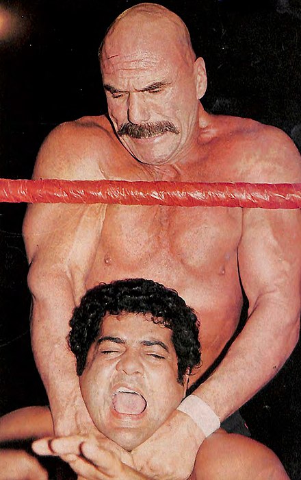 Morales (bottom) during a match against Superstar Billy Graham (top), circa 1983