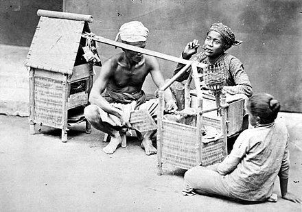 Satay seller in Java, c. 1870. Note the ketupat hanging behind the vendor.