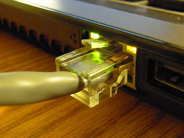 An Ethernet port on a laptop computer connected to a twisted pair cable with an 8P8C modular connector