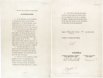 7 Mayıs 1945 tarihinde Fransa'nın Reims şehrinde Müttefik Sefer Kuvvetleri Yüksek Karargâhı'nın bulunduğu binada imzalanan Almanya'nın teslimiyet belgesi. İmzalar: Generaloberst Alfred Jodl (OKW'nin adına ve yeni devlet başkan Karl Dönitz'in temsilcisi olarak), Müttefik Sefer Kuvvetleri Yüksek Karargâhı kurmay başkanı Amerikalı Korgeneral Walter Bedell Smith (Batı Müttefik Kuvveleri adına), Kızıl Ordu iletişim subayı Tümgeneral İvan Susloparov (Sovyetler Birliği Yüksek Komtanlığı adına) ve Fransa Kara Kuvvetleri'nden Tümgeneral François Sevez (resmî tanık olarak). (Üreten: Office of War Information, ABD)