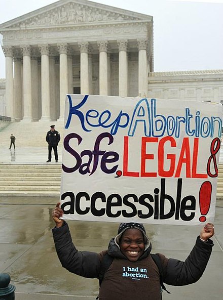 An advocate for the right to safe and legal abortion demonstrates with a sign