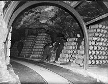 Storemen stack 250 lb (110 kg) general purpose bombs in a tunnel of an RAF Ammunition dump, which exploded in 1944. RAF Fauld tunnel bombs.jpg