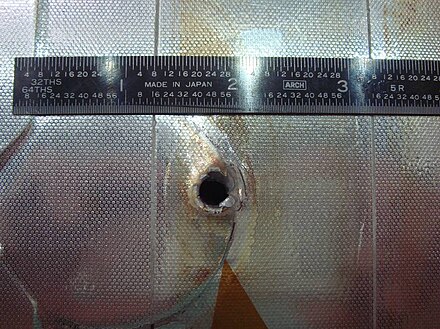Space Shuttle Endeavour had a major impact on its radiator during STS-118. The entry hole is about 5.5 mm (0.22 in), and the exit hole is twice as large.