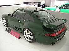 Une Porsche 911 Turbo S verte vue de trois-quart arrière.