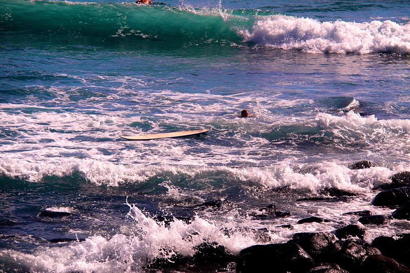 File:Surfboard washed onto the rocks.jpg