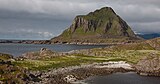 Foto eines felsigen Berges auf einer Insel, von einer flachen Nachbarinsel aus fotografiert