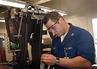 US Navy 040609-N-4385W-003 Aviation Structural Mechanic 2nd Class Dane Welch, from Houwa, La., performs maintenance on a Martin-Baker MKGREA7 ejection seat.jpg