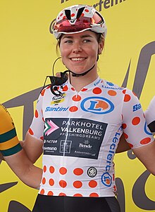 Die Radsportlerin Femke Markus sitzt auf ihrem Rad. Sie trägt das gepunktete Trikot.