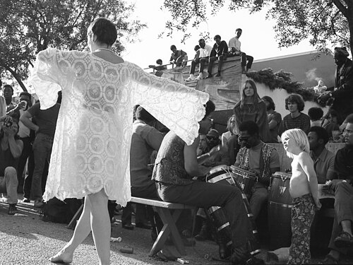 Woman in white dancing amidst a crowd of people, Berkeley, April 1971